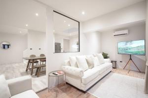 a living room with a white couch and a flat screen tv at Somewhere house in Bangkok