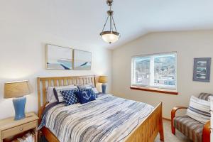 a bedroom with a bed and a chair and a window at Ninos Al Mar in Rockaway Beach