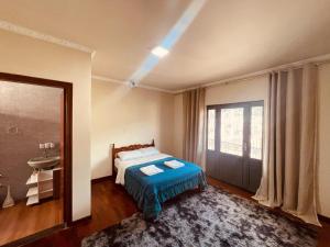 a bedroom with a bed and a sink and a window at Apto Cobertura Santa Rosalia in Poços de Caldas