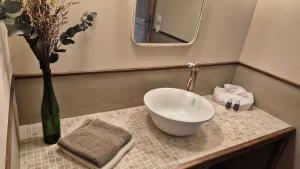 a bathroom with a sink and a vase with flowers at chambre saint emilion - Le Clos d'Antan in Les Artigues-de-Lussac
