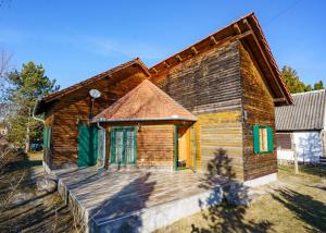 a wooden house with a large wooden deck at Zöldfenyő nyaraló, Ferienhaus Tannengrün in Balatonkeresztúr