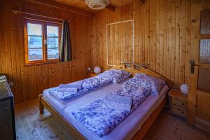 a bedroom with a bed in a wooden cabin at Zöldfenyő nyaraló, Ferienhaus Tannengrün in Balatonkeresztúr