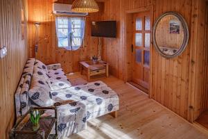 a living room with a couch and a mirror at Zöldfenyő nyaraló, Ferienhaus Tannengrün in Balatonkeresztúr