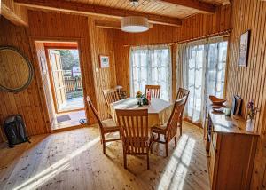 a wooden dining room with a table and chairs at Zöldfenyő nyaraló, Ferienhaus Tannengrün in Balatonkeresztúr