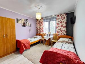 a bedroom with two beds and a table and chairs at U Dany in Białka Tatrzanska