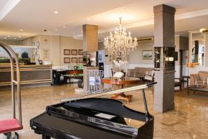 sala de estar con piano y comedor en Hotel Dan Inn Araraquara by Nacional Inn, en Araraquara