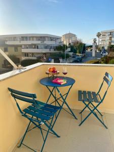 un tavolo con due sedie e un bicchiere di vino sul balcone di La Tana Alghero ad Alghero