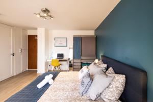 a bedroom with a bed with pillows on it at Le cottage roannais in Roanne