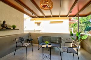 a patio with chairs and tables and a chandelier at Villa Savaaya Assagao Goa in Assagao