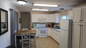 a kitchen with white appliances and a wooden table at Alpaca Rustic Ranch-peaceful & breathtaking views in Santa Clarita