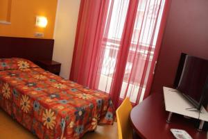 a bedroom with a bed and a tv and a window at Meublé Nautic Rooms b&b in Cesenatico