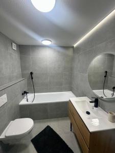 a bathroom with a tub and a toilet and a sink at Pieninská apartment in Banská Bystrica