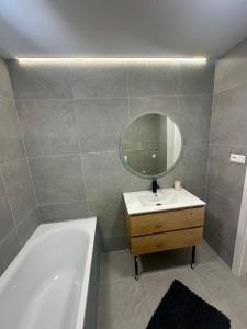 a bathroom with a tub and a sink and a mirror at Pieninská apartment in Banská Bystrica +2 photos