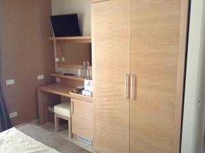 a bedroom with a wooden cabinet with a desk at Hotel C'era Una Volta in Castiglione della Pescaia