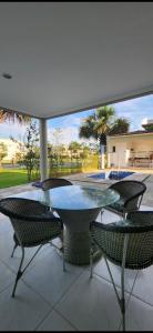 a glass table and chairs on a patio at Casa de alto padrão para COP30 in Belém
