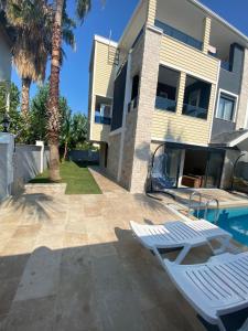 two white lounge chairs in front of a house at Villa Pars Antalya Three story villa, private pool and roof terrace Three Bedroom Accommodation for six Guests in Belek