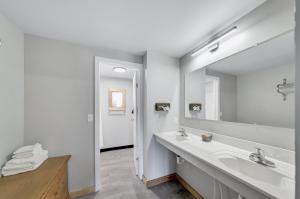 bagno con lavandino e grande specchio di Lantern Inn a Hill City Altre 32 foto