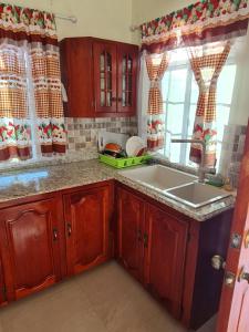 a kitchen with wooden cabinets and a sink at Paradise place Grande twin beds in Discovery Bay