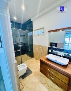 a bathroom with a shower and a toilet and a sink at Sinhavilla Bentota in Bentota +21 photos