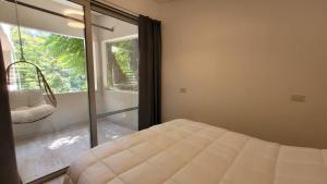 a bedroom with a bed and a large window at La Belle San Isidro Lofts in San Isidro