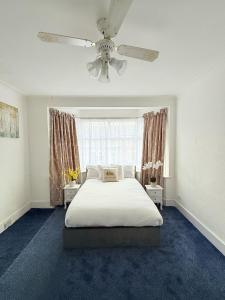 a bedroom with a bed and a ceiling fan at Luxury House in Ilford 21 minute Train journey from Central London in Ilford +38 photos