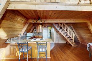 a kitchen with a spiral staircase in a log cabin at Pirate's Paradise in Lincoln City