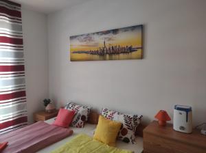 a room with a couch with pillows and a painting on the wall at Orange Studio on Sunny Day 6 Complex in Tŭnkovo +38 photos