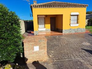 a yellow house with a brick pillar in front of it at Villa Encanto Chiclana in Novo Sancti Petri