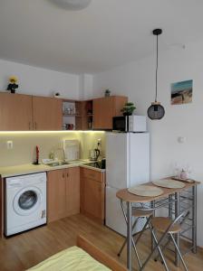 a kitchen with a washing machine and a table at Orange Studio on Sunny Day 6 Complex in Tŭnkovo