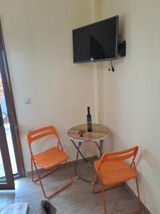 ein Zimmer mit zwei Stühlen, einem Tisch und einem Fernseher in der Unterkunft Diolkos 2 in Nea Roda