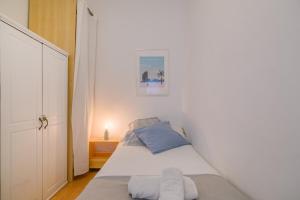 a small bedroom with a bed in a white room at Playa a pie y a 15 minutos de Ramblas y Plaza Catalunya en metro in Sant Adria de Besos
