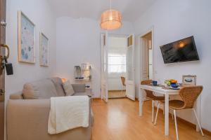 a living room with a couch and a table at Playa a pie y a 15 minutos de Ramblas y Plaza Catalunya en metro in Sant Adria de Besos