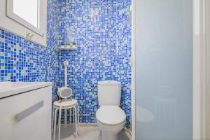 a blue tiled bathroom with a toilet and a shower at Playa a pie y a 15 minutos de Ramblas y Plaza Catalunya en metro in Sant Adria de Besos +52 photos