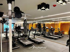 a gym with several tread machines and a mirror at Alta Garden- Pé Na Areia- MH in João Pessoa