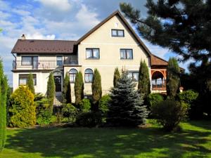 a large house with a tree in the yard at U Macieja z kortem tenisowym in Kłodzko