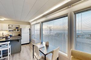 a kitchen with a table and chairs and windows at Wycliff Beach Condo in Lincoln City +30 photos