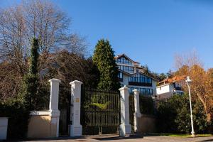 a large house with a gate and a house at Vistas y Golf en Adosado Pedreña in Pedreña
