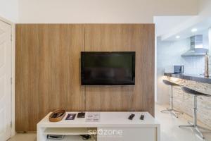 a living room with a tv on a wall at Apto térreo a 5min da Praia do Forte EMA101 in Škorak