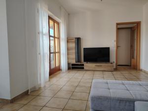 a living room with a flat screen tv and a couch at Gemütliche 100 qm Wohnung mit Balkon in Wernsdorf