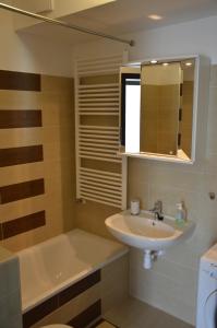 a bathroom with a sink and a bath tub and a sink at D-S Apartman Stella in Zamárdi +5 photos