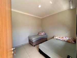 a small room with two beds and a ottoman at Cantinho Guimarães in Olímpia +11 photos