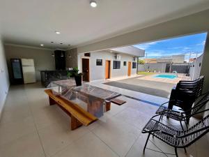 a living room with a table and chairs and a pool at Cantinho Guimarães in Olímpia