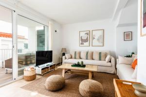 Una sala de estar con un sofá y un televisor. en La Casita de Arum, en Es Mercadal