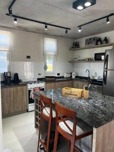 a kitchen with a counter with two chairs and a island at Costa Esmeralda Casa Ecu in Costa Esmeralda