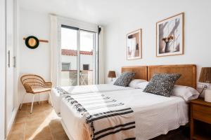 Un dormitorio blanco con una cama y una ventana. en La Casita de Arum, en Es Mercadal 29 fotos más