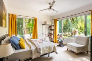 a bedroom with a bed and a chair and a window at Lux 4BR Playacar Villa with Pool in Playa del Carmen +34 photos