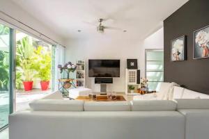 a white living room with a large white couch at Lux 4BR Playacar Villa with Pool in Playa del Carmen