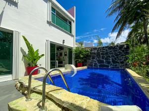 a swimming pool in front of a house at Lux 4BR Playacar Villa with Pool in Playa del Carmen