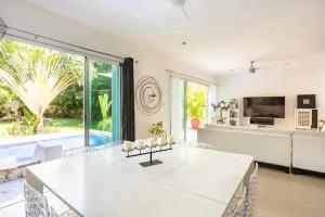 a living room with a white table and a couch at Lux 4BR Playacar Villa with Pool in Playa del Carmen