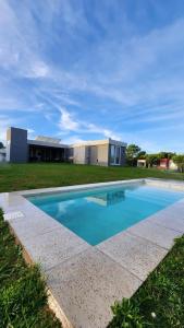 a swimming pool in front of a house at Costa Esmeralda Casa Ecu in Costa Esmeralda